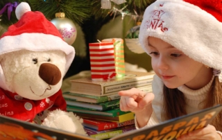 Child wearing a Santa hat reading a book